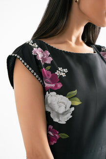 Black top with floral print on a plain background